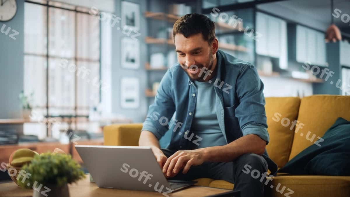 Er divanga choyxona stolga yonida laptop bilan o'tirgan. | Man sits couch coffee table with laptop 1