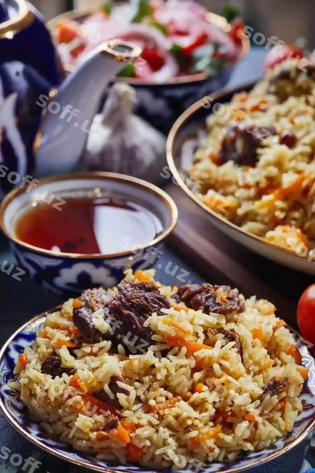 O'zbek palovi haqiqiy ko'k oltin mahsulot ko'k fonsli surat pomidorlar, sarimsoq va choy bilan | Uzbek pilaf authentic blue gold dish shot blue background with tomatoes garlic tea