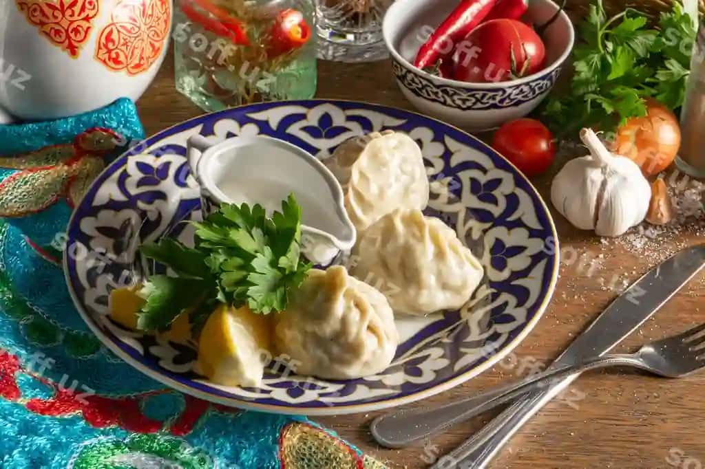 An'iyviy o'zbek qo'lma manti guruch qırmızı va piyoz bilan to'ldirilgan, sharqaviy souse (smetana, tuz, qalap, sarimsoqdan tayyorlangan) bilan xizmat qilinishadi. An'iyviy o'zbek naqshli disk. | Traditional uzbek hand made manti steamed with minced lamb onion filling with oriental sauce made sour cream salt pepper garlic plate with traditional uzbek pattern