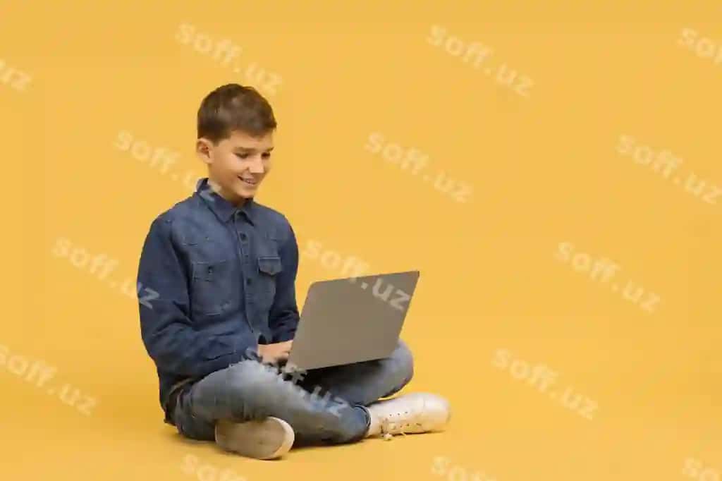 Gulbandidi o'smir bola polga o'z o'rniga o'tirib noutbukdan foydalangan holda | Smiling teenage boy sitting crosslegged floor using laptop