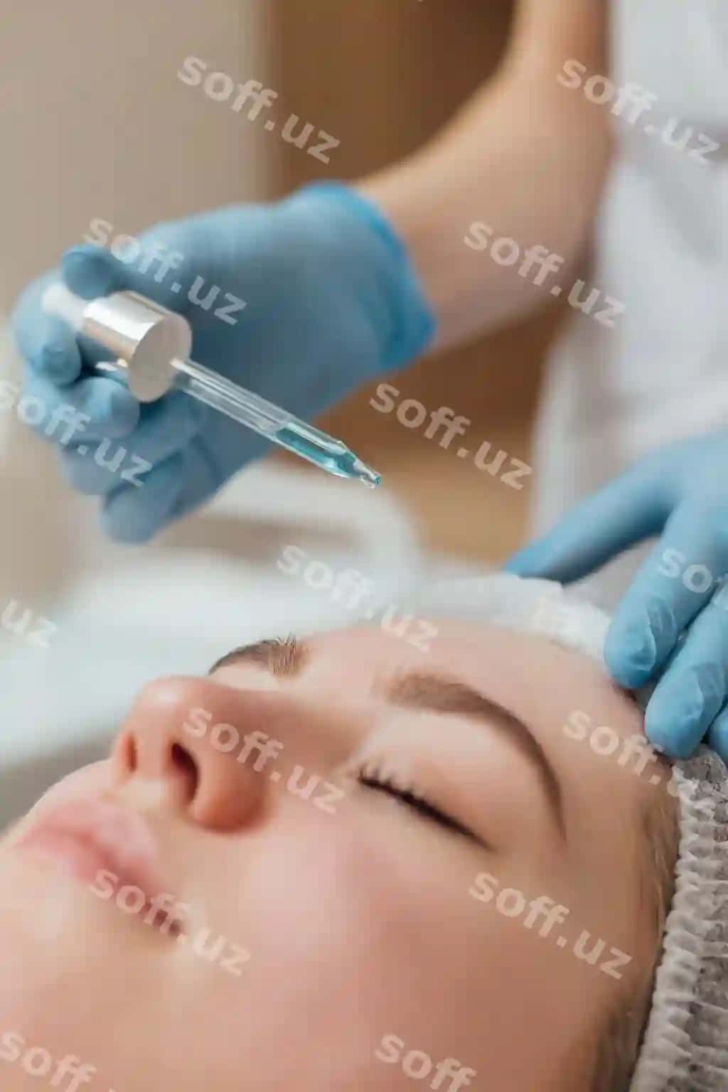 Beautician yuzga tozalash va nafislik vositigini damagich bilan qo'llaydi. | Beautician applies cleanser moisturizer face with dropper