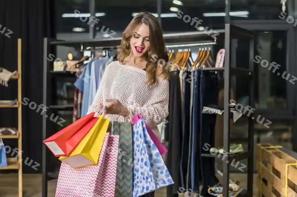 Hursand ayol rangli xarid baglarining ichiga qarayotgan. | Excited woman looking inside colorful shopping bags
