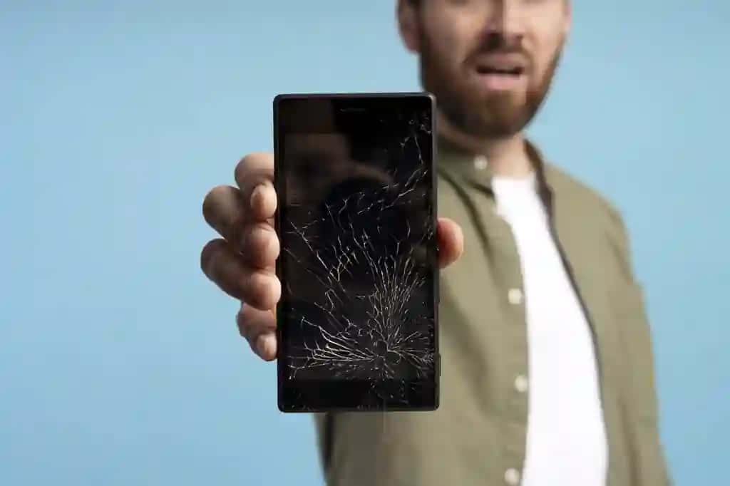 Singan ekranli uyali telefon studiyasi izolyatsiya qilingan ko'k fonni ko'rsatayotgan odamni yoping | Close up man showing broken screen cell phone studio isolated blue background