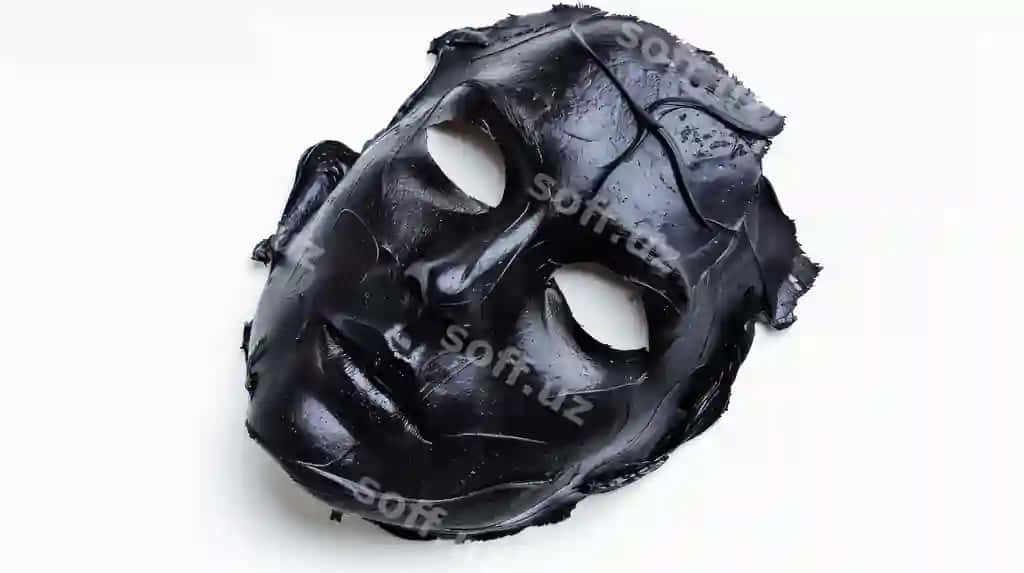 Yassi oq yuzada yotgan qora yuz niqobi uning tuzilishini namoyish etadi | Black facial mask lying flat white surface showcasing its texture