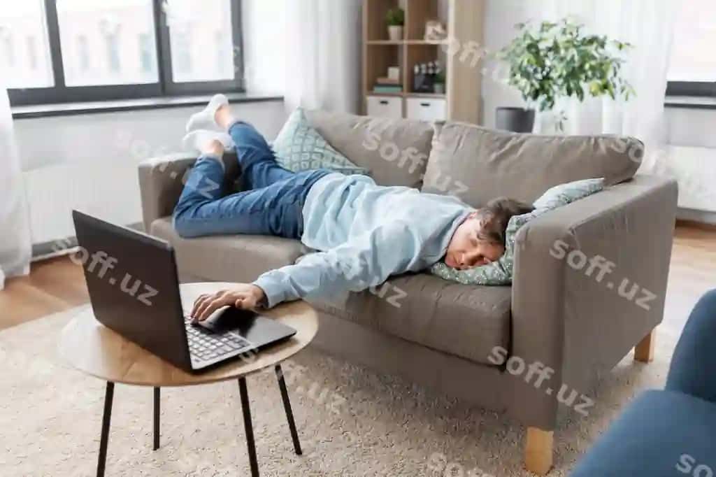 Boshlangan erkak laptop bilan uyda divanga yotgan. | Bored man with laptop lying sofa home