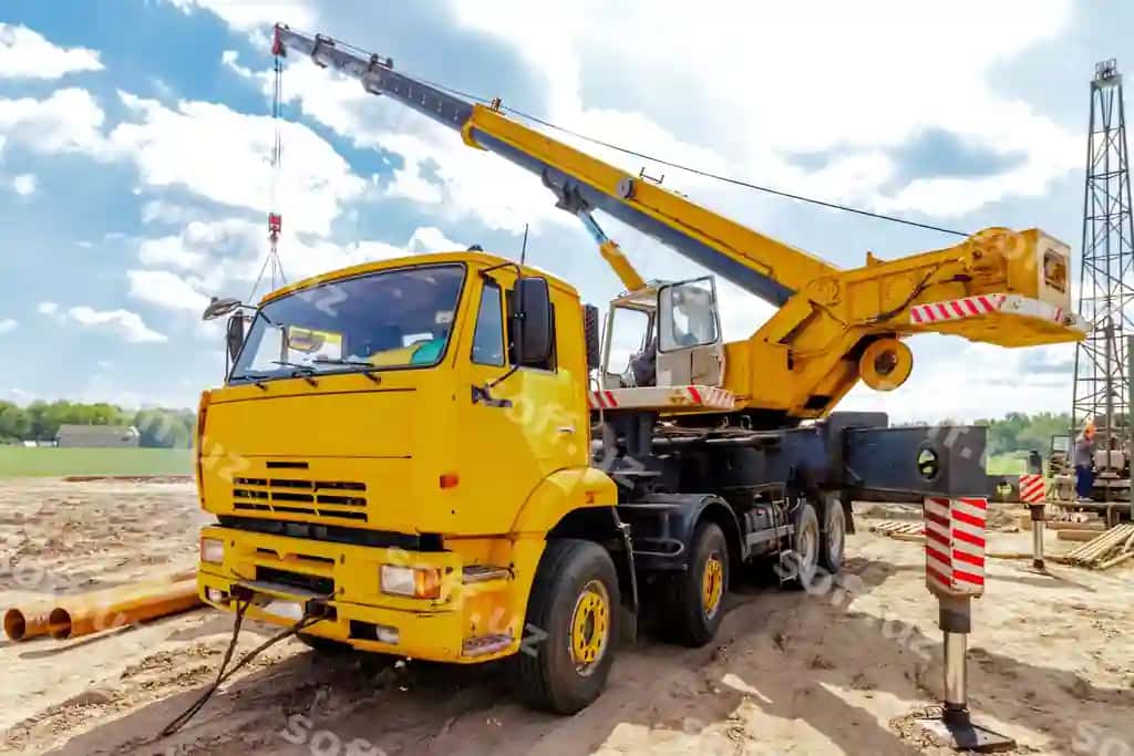 Katta sariq truck kran qurilish joyida ishga tayyor turibdi. | Large yellow truck crane stands ready work construction site