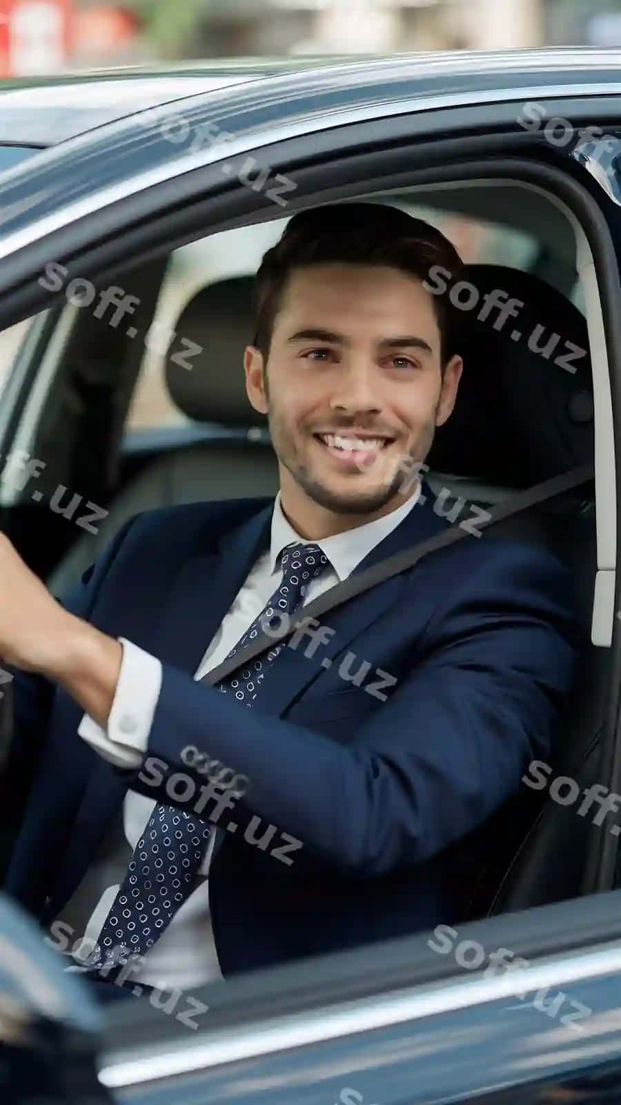 Joziboi yosh biznesmen to'liq kostyumda yangi mashina haydashda gulchi koeffecientda | Handsome young businessman full suit smiling while driving new car