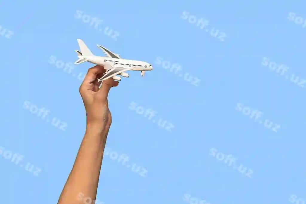 Ayol qo'lida kichik oq samolyot, qo'l ko'k fonda sayohat konsepsiyasi | Woman s hand holds small white airplane her hand blue background travel concept